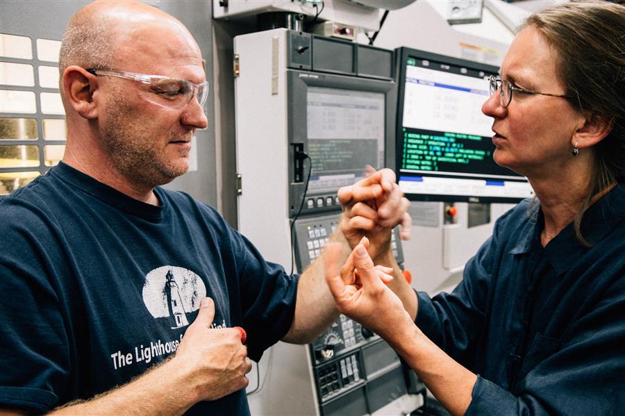 An interpreter using tactile sign language to communicate with a consumer.